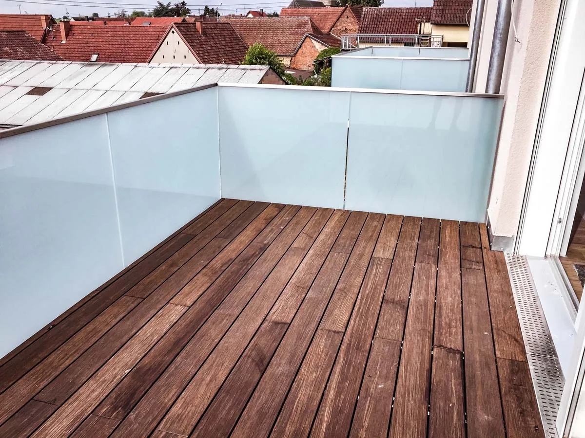 Balkon mit Glasgeländer aus Milchglas und Holzbelag