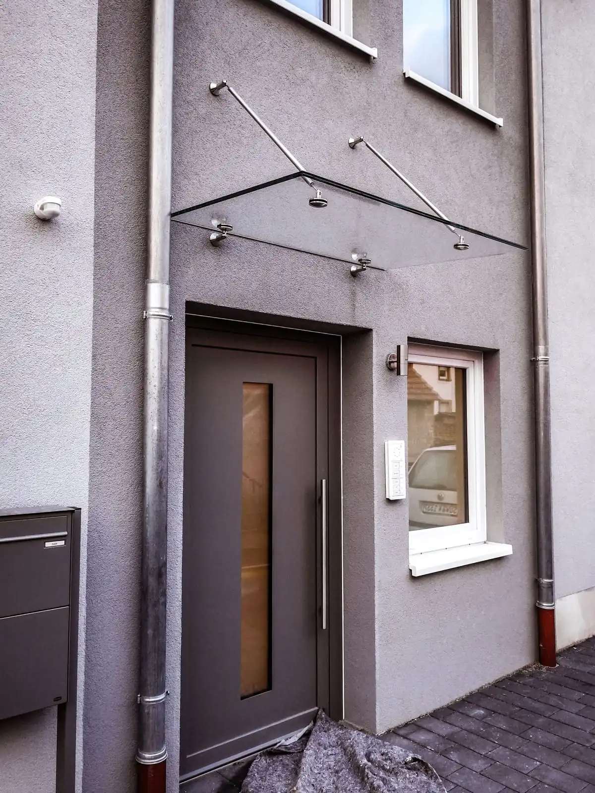 Glasvordach mit Edelstahl-Zugstäben und Punkthaltern an der Haustür