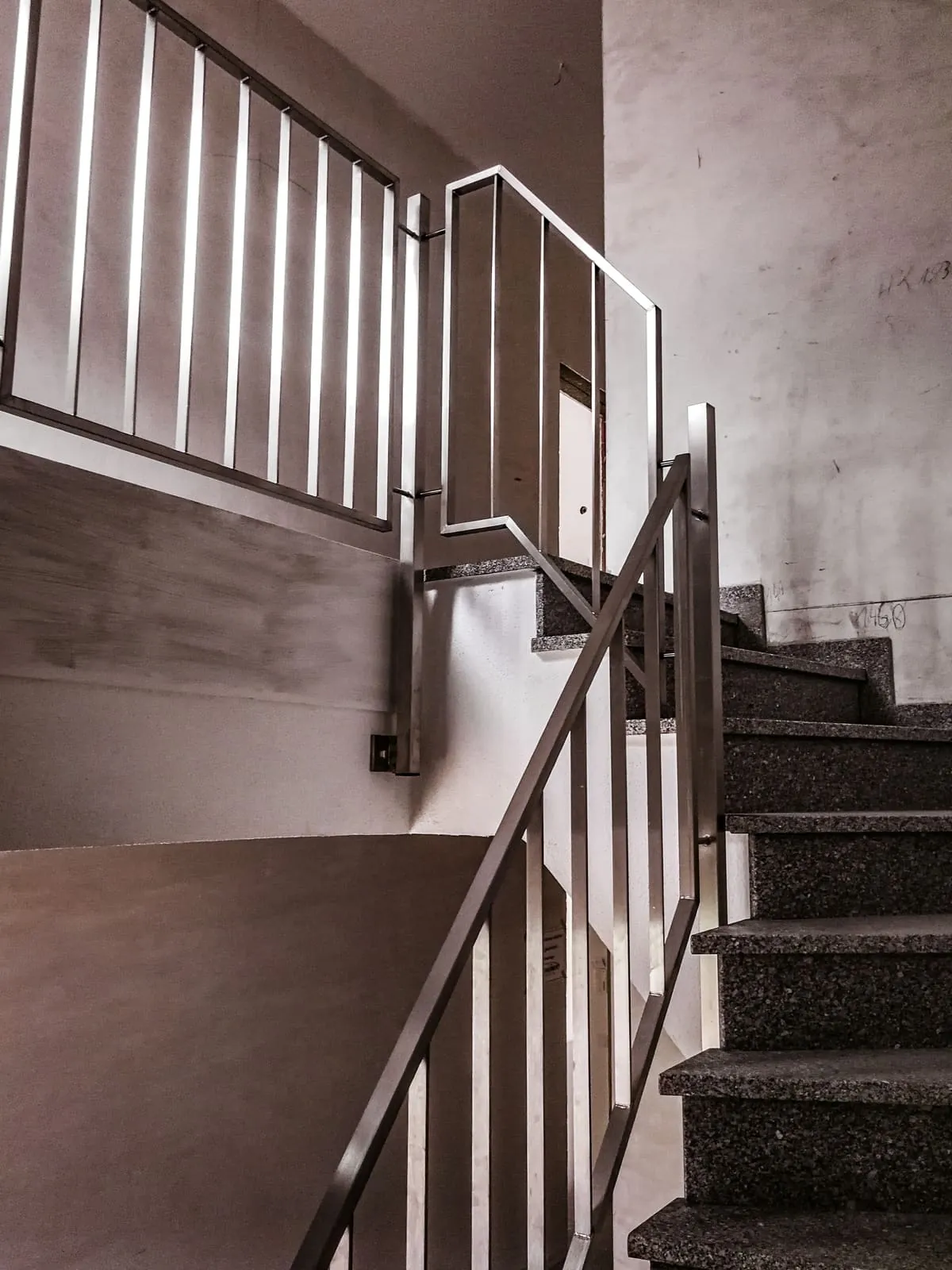 Edelstahlgeländer mit Stabfüllung an Granitstufen im Treppenhaus, Untersicht