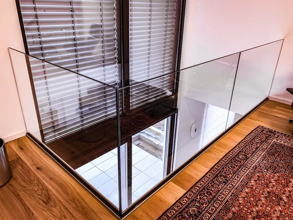 Rahmenloses Glasgeländer an Galerie mit Fensterfront innen