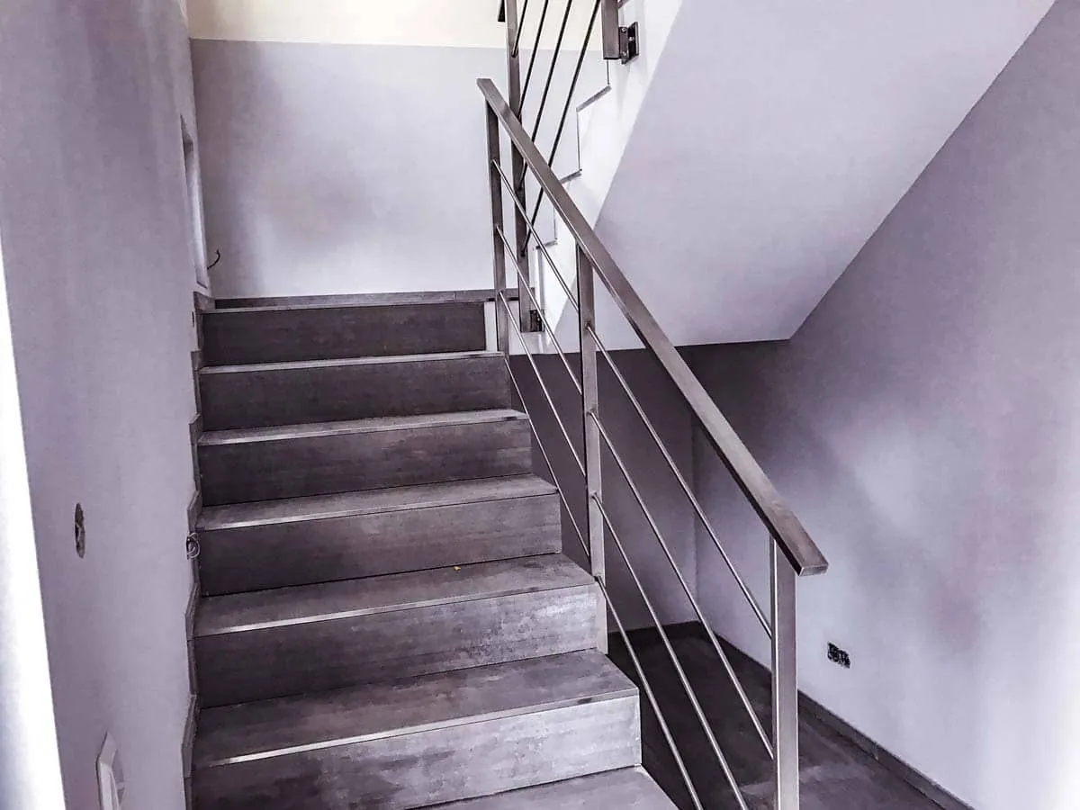 Treppengeländer aus Edelstahl mit Horizontalstäben an Betontreppe innen