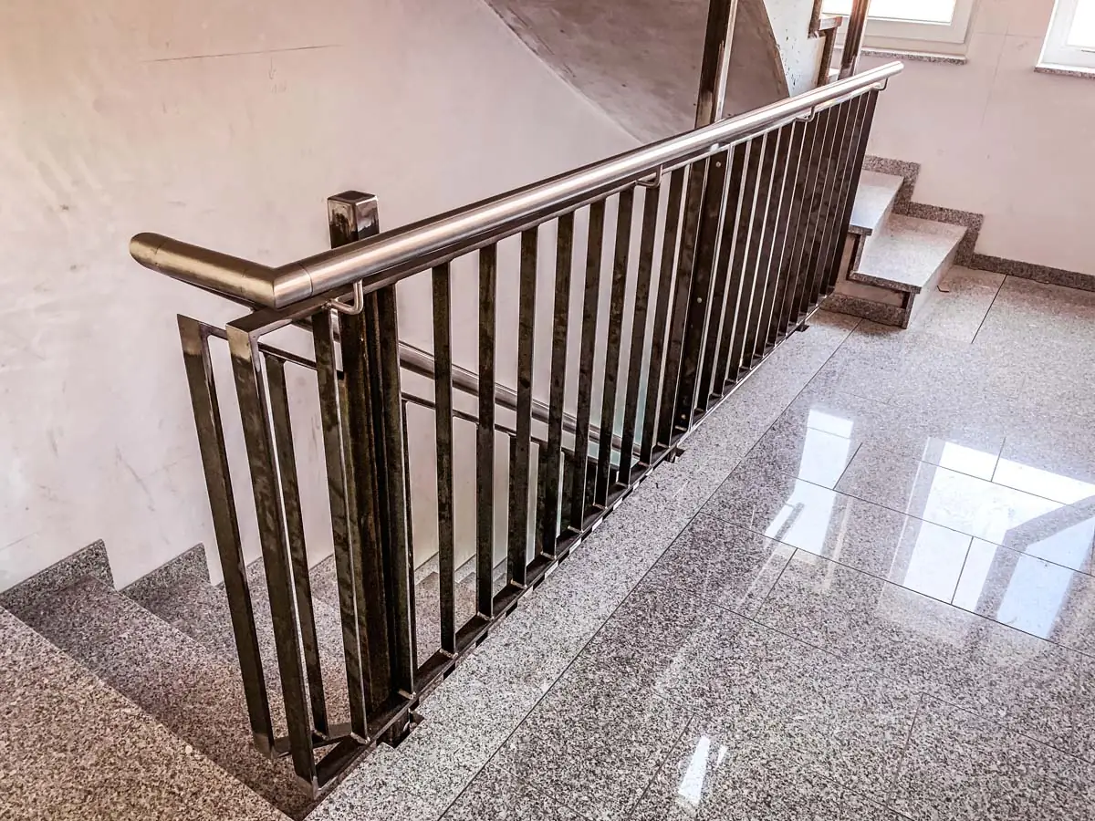 Treppengeländer aus Stahl mit Flachstabfüllung und Edelstahlhandlauf im Treppenhaus