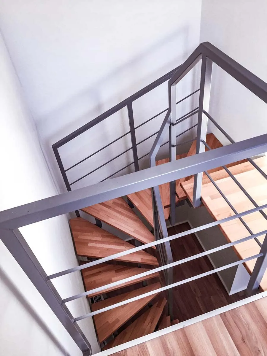 Treppengeländer aus Stahl mit Horizontalstäben an Spindeltreppe mit Holzstufen