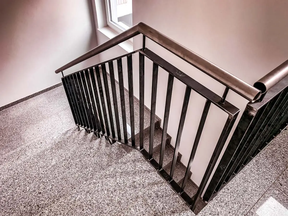 Treppengeländer aus Stahl mit Stabfüllung und Edelstahlhandlauf an Granit