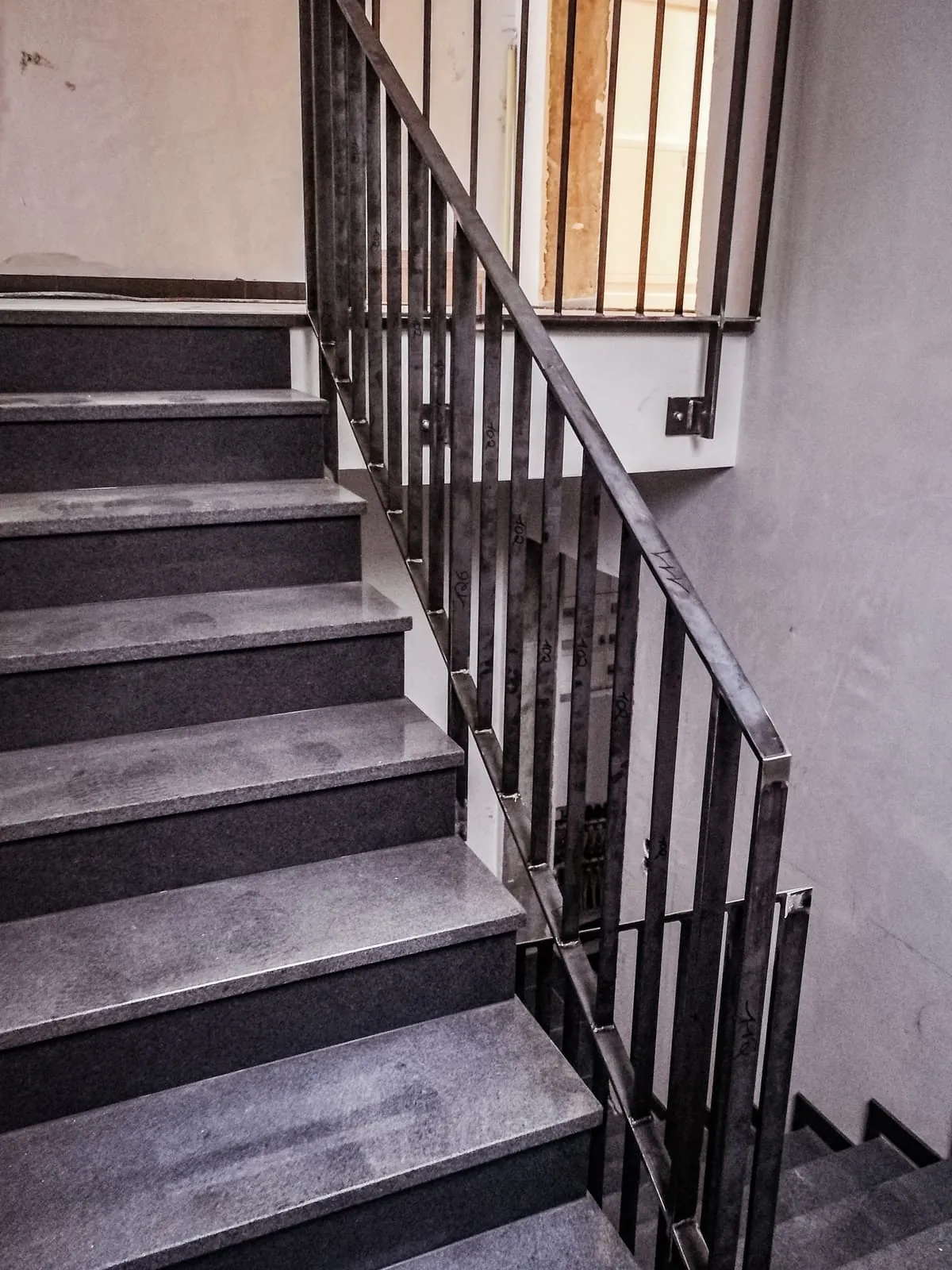 Treppengeländer aus Stahl mit Stabfüllung aus Flachstahl im Treppenhaus