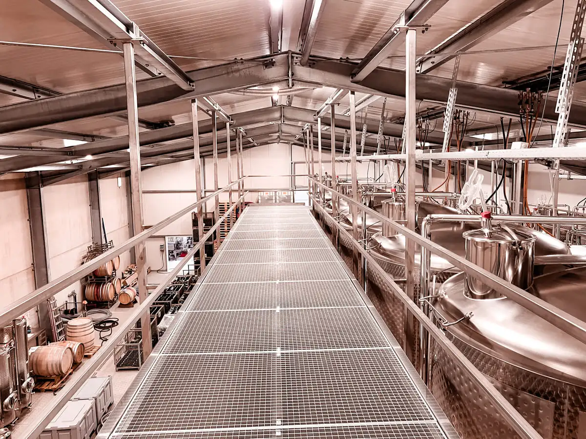 Stahlbühne mit Gitterrost im Weinkeller zwischen Weintanks in Bad Bergzabern