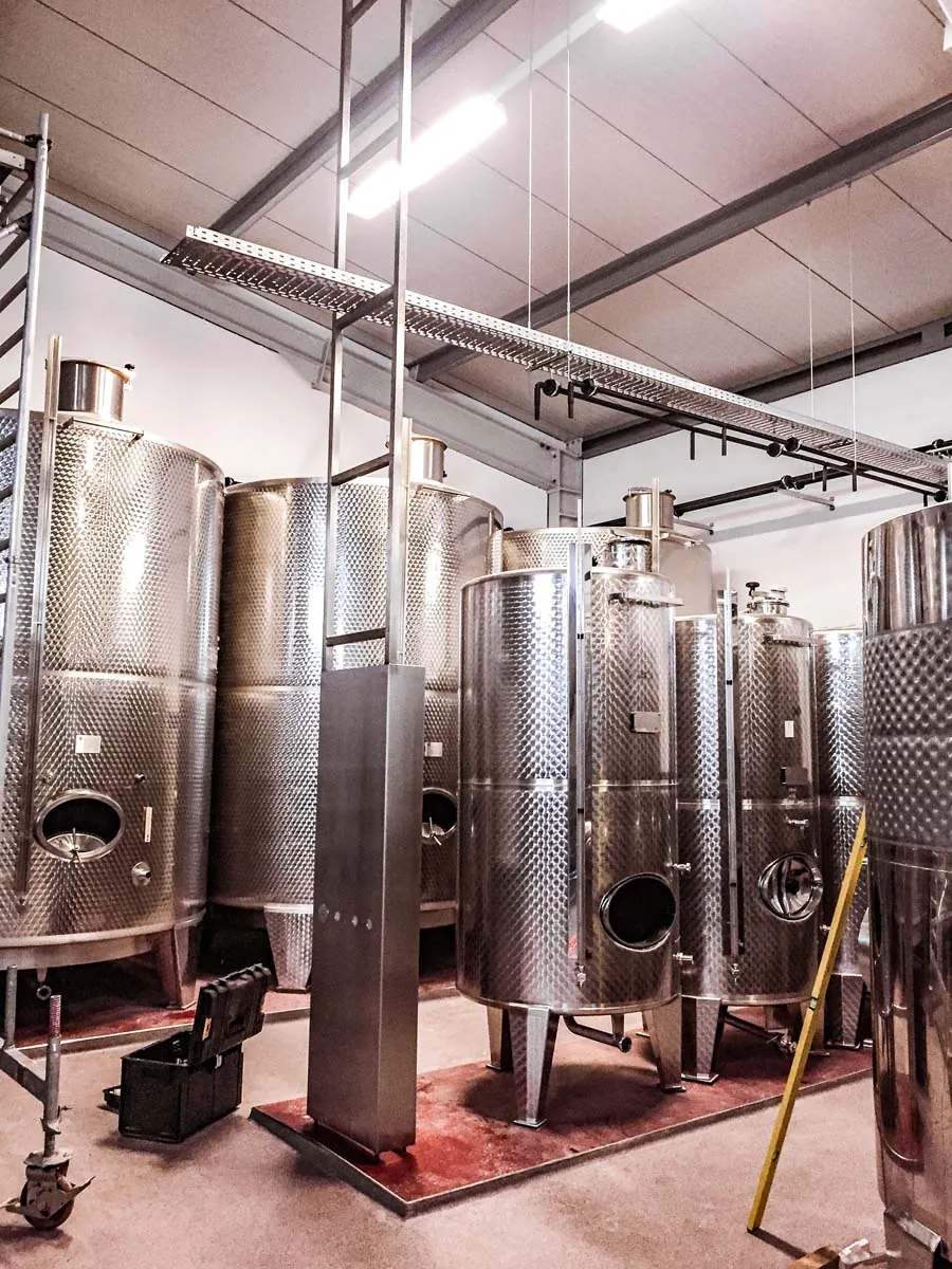 Edelstahl-Weintanks mit Leitungen in einer Kellerei