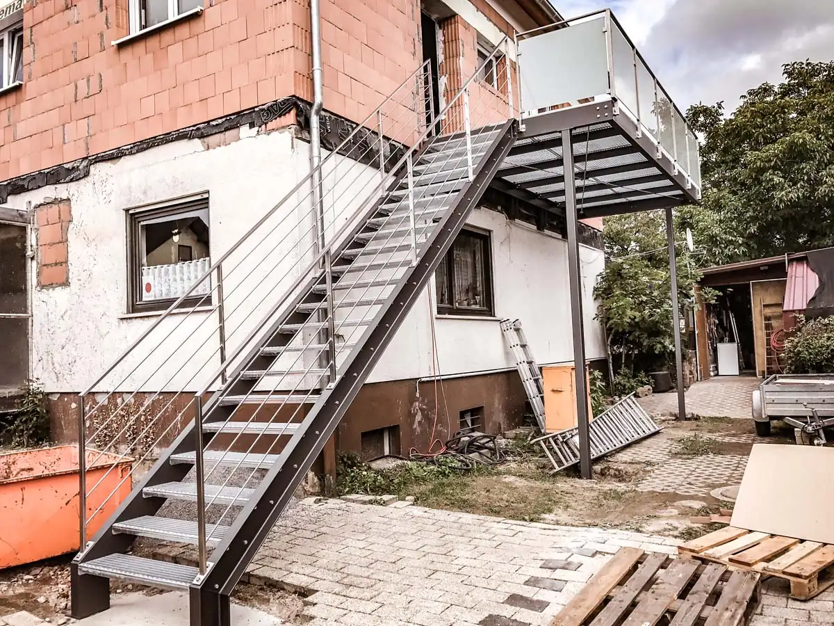 Außentreppe aus Stahl mit Balkon und Glasgeländer als Anbau