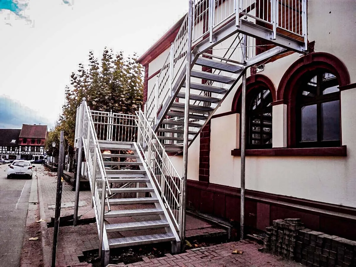 Verzinkte Podesttreppe an Altbau-Fassade, weitere Ansicht