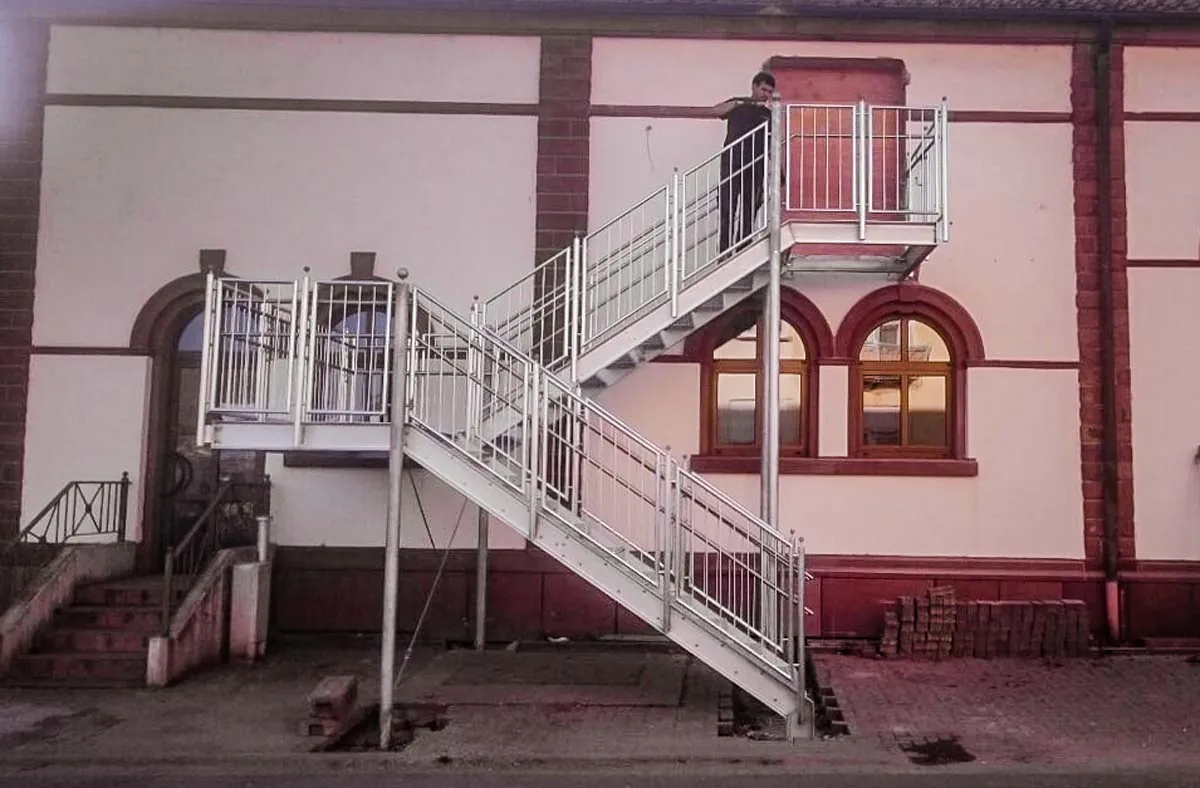 Verzinkte Podesttreppe an Altbau-Fassade