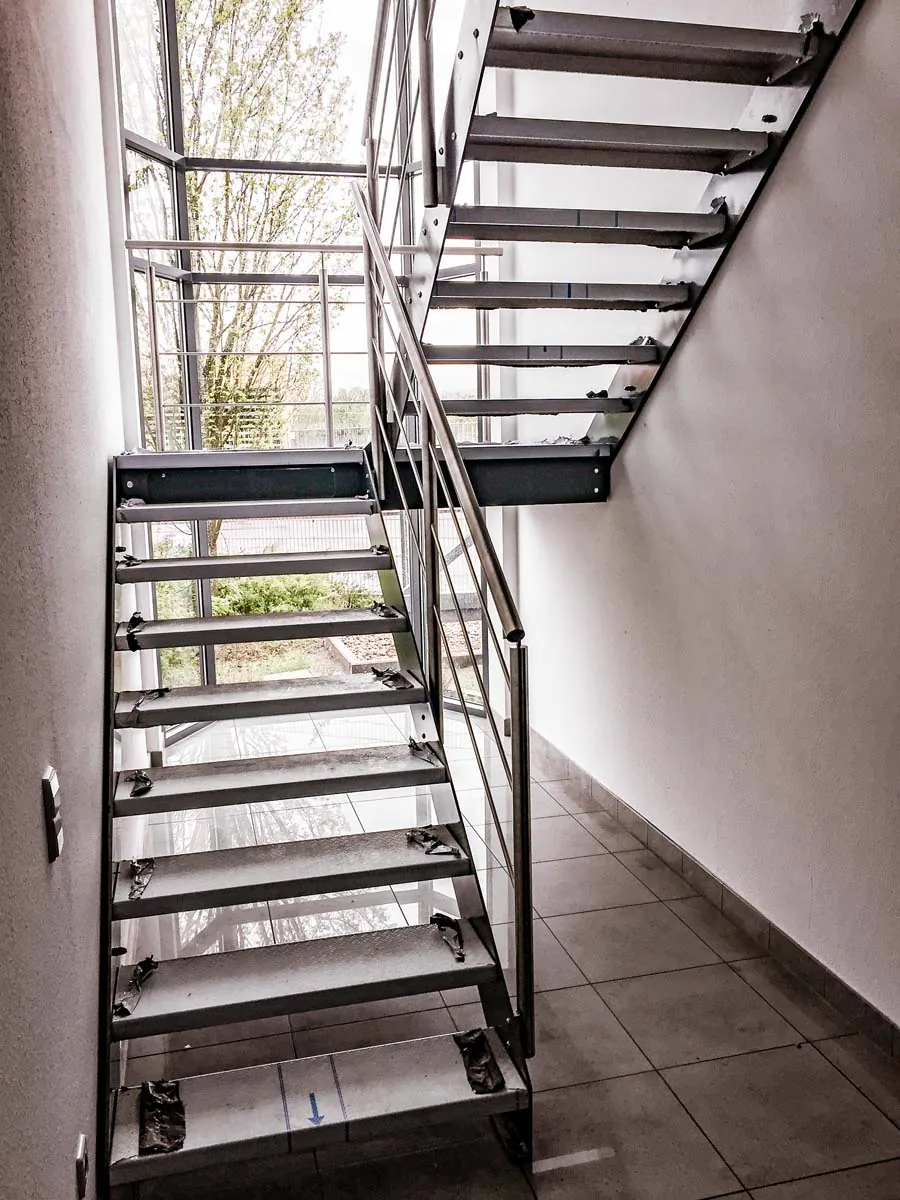 Innentreppe aus Stahl im Treppenhaus mit Edelstahlgeländer