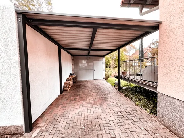 Carport aus Stahl mit Trapezblech am Hausdurchgang