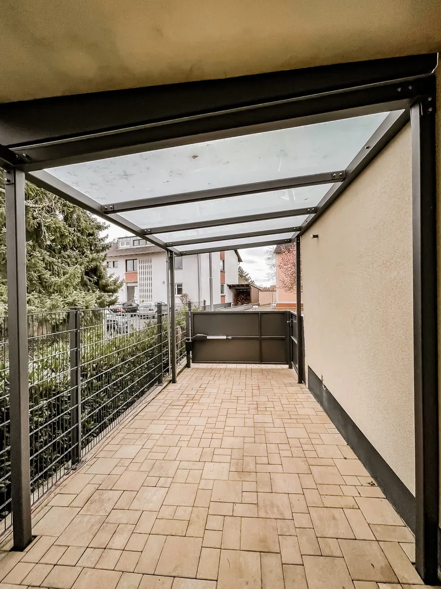 Überdachung mit Glasdach am Durchgang mit Geländer